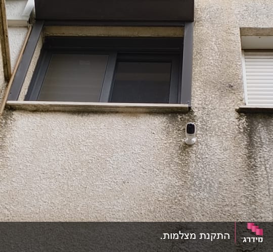 מצלמת אבטחה מותקנת על קיר חיצוני של בניין